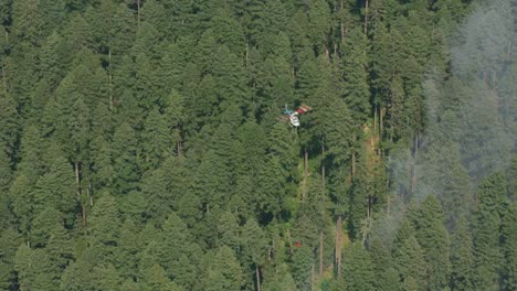 Aerial-shot-of-helicopter-dropping-water-on-forest-fire.