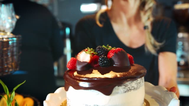 Waitress-Holding-Freshly-Baked-Cake-With-Buttercream-Frosting