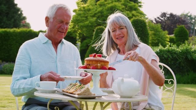 Ehepaar-im-Ruhestand-Nachmittagstee-im-Garten-zu-Hause-genießen