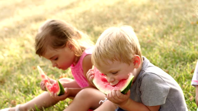 Grupo-de-niños-comiendo-sandía-en-verano-Parque