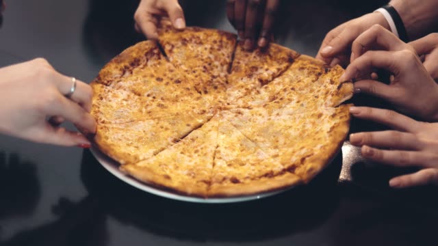 Human-hands,-taking-bits-and-pieces-of-delicious-pizza-from-a-plate.-Close-up