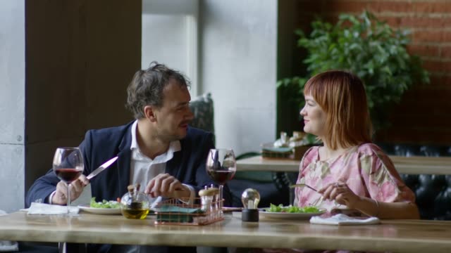 Cheerful-Couple-Eating-Salad-on-Date