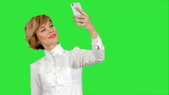 Empresaria-teniendo-divertido-selfie-con-teléfono-en-una-pantalla-verde-Chroma-Key