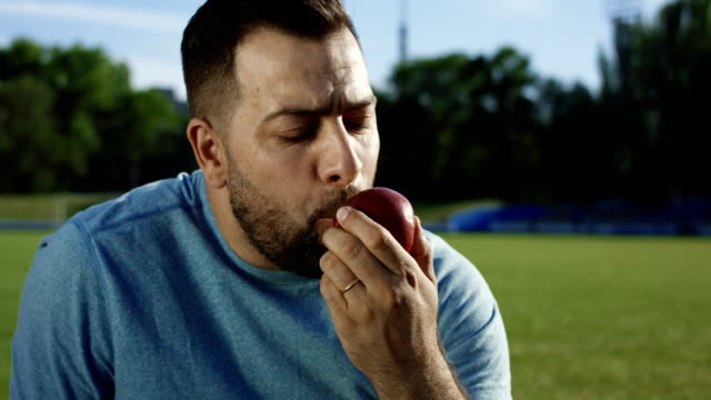 Hombre-feliz-con-apple-en-el-campo-de-atletismo
