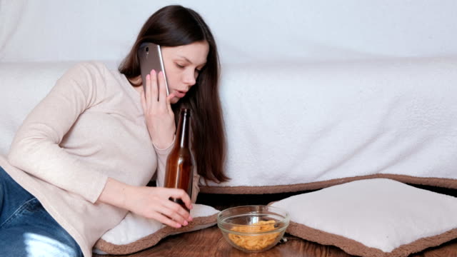 Tough-conversation-to-women-on-the-phone.-She-eats-chips-and-drinks-beer.