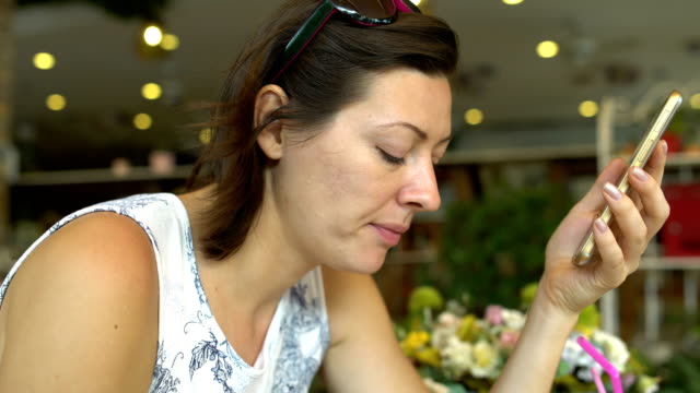 Frau-in-einem-Restaurant-Essen-und-genießt-eine-Smartphone