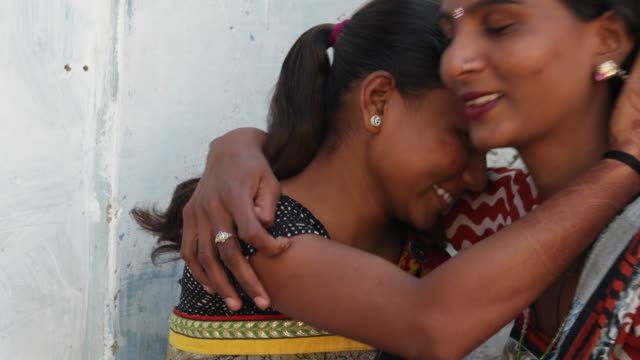 Zwei-Freundinnen-Teilen-Unterstützung-Umarmung-Umarmung-Liebe-Familie-Schwester-Beste-Freunde-helfen,-Lächeln,-Lachen-zusammen-kleben-Closeup-statische-Kamera-nach-Hause-innen-Rajasthan-Indien-Dorf-asiatischen-buntes-Kleid-Kostüm