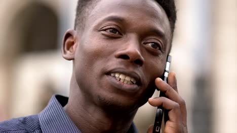 Lächelnd-attraktive-junge-Afrikaner-sprechen-von-Telefon-Close-up