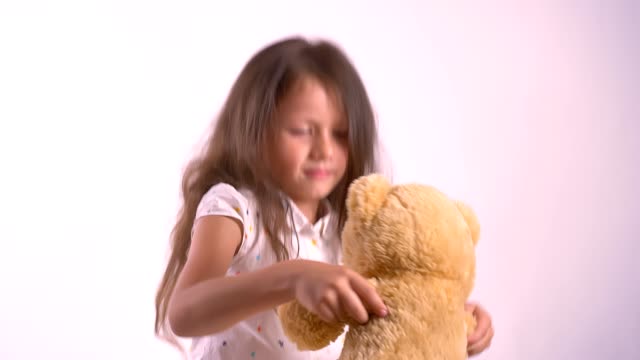 Wenig-kid-mit-Plüsch-Teddybär-spielen-und-tanzen,-mit-Spielzeug,-stehend-auf-Rosa-Studio-hintergrund-isoliert