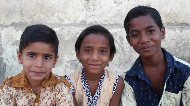 Tres-niños-indianos-sentado-y-mirando-a-la-cámara-y-hablando