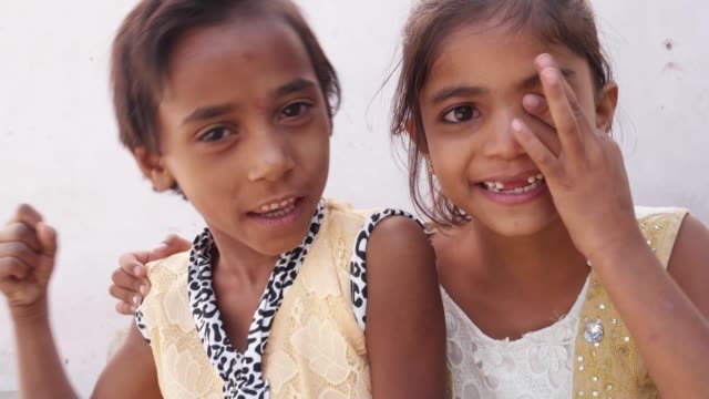 Zwei-junge-Schwestern-ihre-Finger-in-die-Kamera,-glücklich-und-lächelnd-zeigen