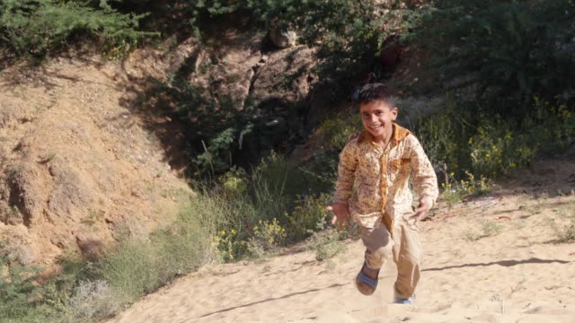 Süße-indische-Kind-laufen-im-Sand-in-Richtung-der-Kamera