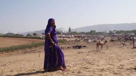 Wide-shot-of-a-woman-on-her-mobile-phone-in-Pushkar-heads-towards-the-camera