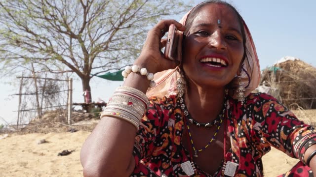 Mujer-rural-tímida,-sociable-y-riendo-en-el-uso-de-un-teléfono-por-primera-vez