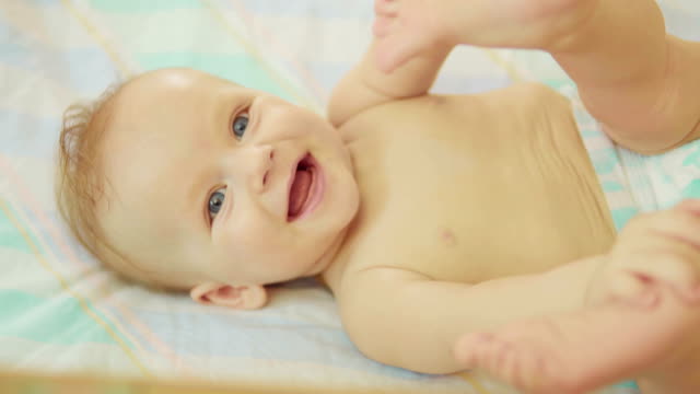 schöne-Neugeborenes-liegend-zurück-schauen-in-die-Kamera-und-lächelnd
