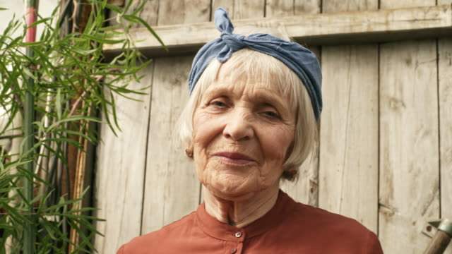 Glücklich-Senior-Frau-Lächeln-für-die-Kamera-in-ihrem-Garten