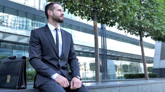 Young-Businessman-Sitting-Outside-OFfice