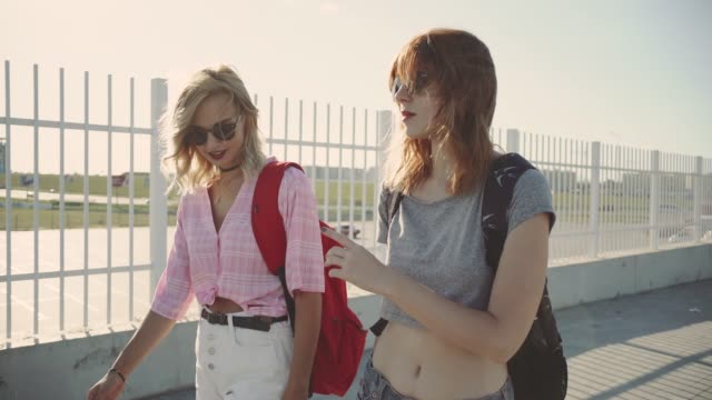 Two-young-attractive-women-talking-and-walking-on-street