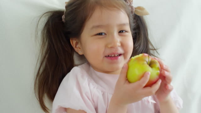 Linda-chica-asiática-comer-manzana