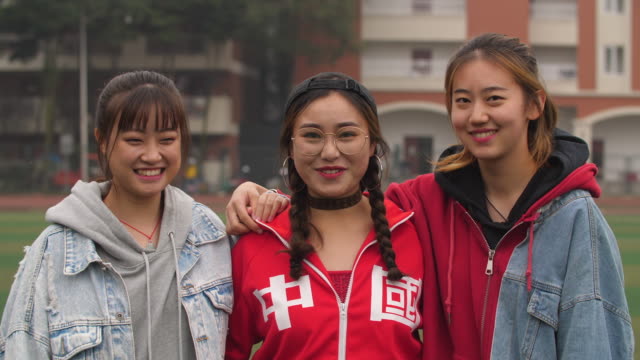 Universidad-asiática-feliz-tres-chica-sonrisa-en-cámara