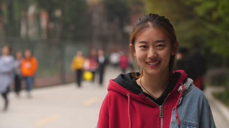 Retrato-de-joven-asiática-sonríe-a-la-cámara-en-campus