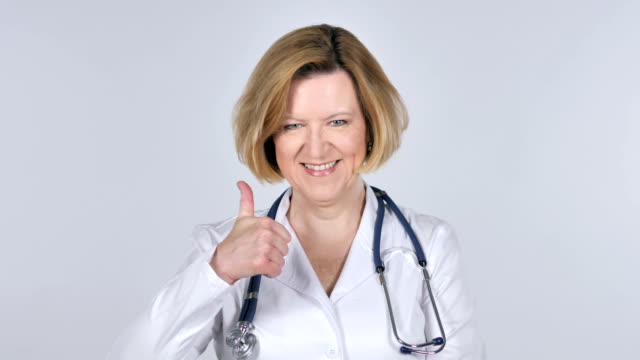 Portrait-of-Old-Doctor-Gesturing-Thumbs-Up