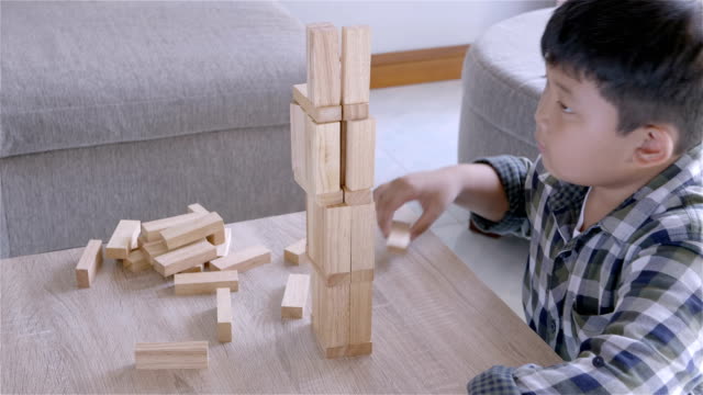 Asiatische-Kinder-junge-spielt-mit-Holzklötzen-Spiel-zu-Hause.