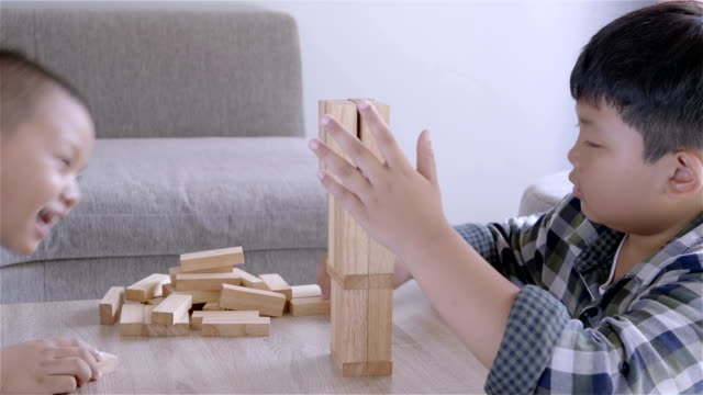 Asian-children-boy-playing-with-wooden-blocks-game-at-home.