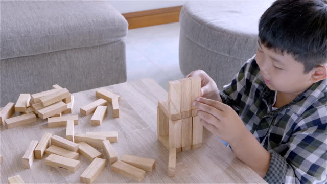 Asiatische-Kinder-junge-spielt-mit-Holzklötzen-Spiel-zu-Hause.