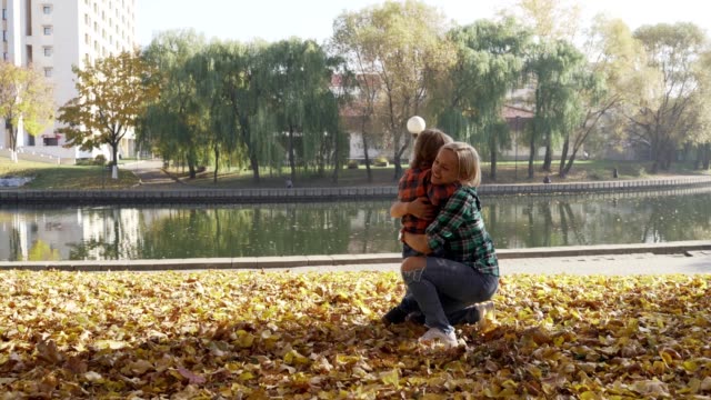 Junge-Mutter,-die-Spaß-mit-ihrem-Sohn-im-Herbst-Park-am-sonnigen-Tag