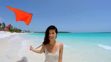 Asiatische-chinesische-Mädchen-am-Strand-spielen-mit-kite