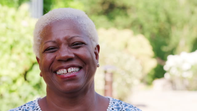 Senior-black-woman-smiling-to-camera-outdoors,-close-up
