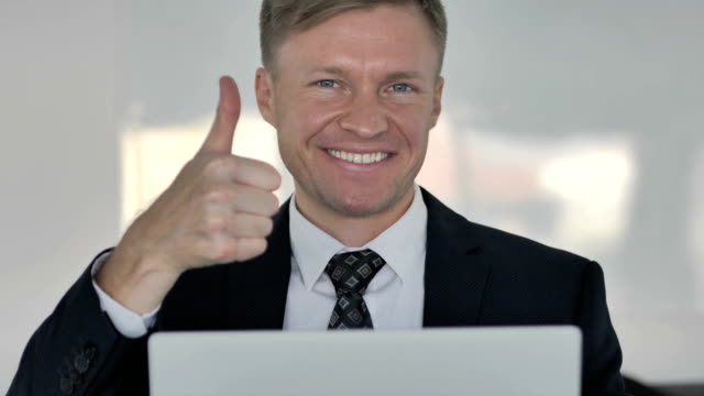 Thumbs-Up-by-Businessman-Looking-at-Camera