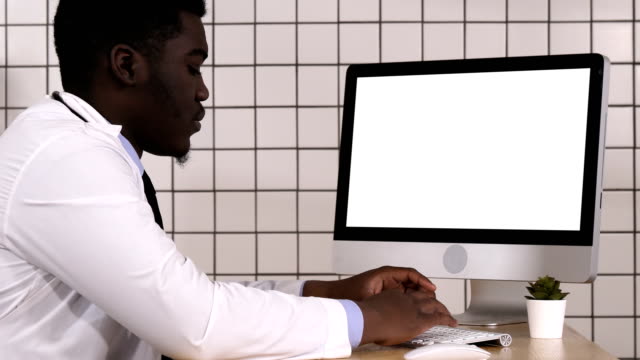Mature-doctor-working-on-computer.-White-Display