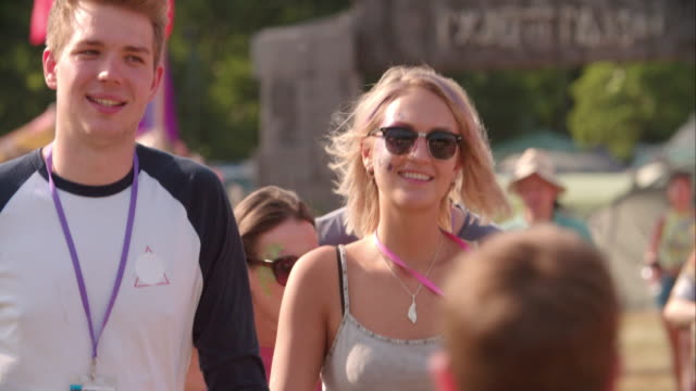 Couple-walking-at-a-music-festival,-slow-motion