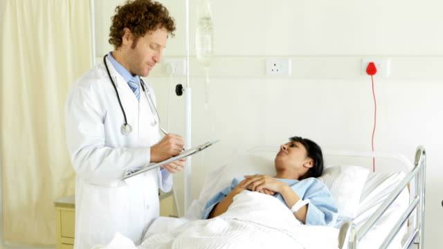 Arzt-im-Gespräch-mit-Kranken-Patienten-im-Bett