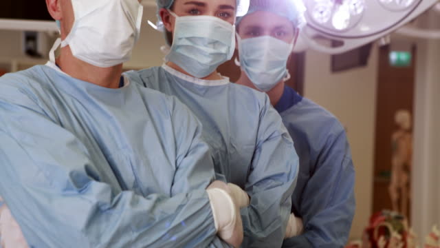 Equipo-quirúrgico-mirando-a-la-cámara-en-la-operación-teatro