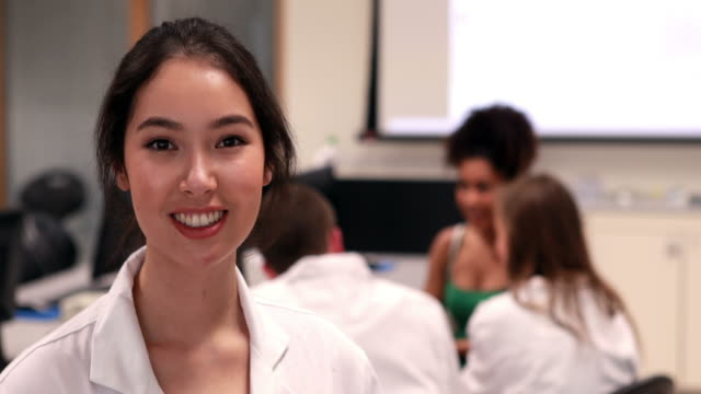 Hübsche-medical-student-lächelnd-in-die-Kamera-in-class
