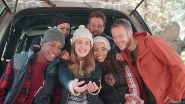 Friends-taking-a-selfie-in-the-open-hatchback-of-a-car