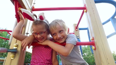 Girl-with-ears-and-glasses-and-boy-with-white-hair-having-fun-on-the-children's-tower.