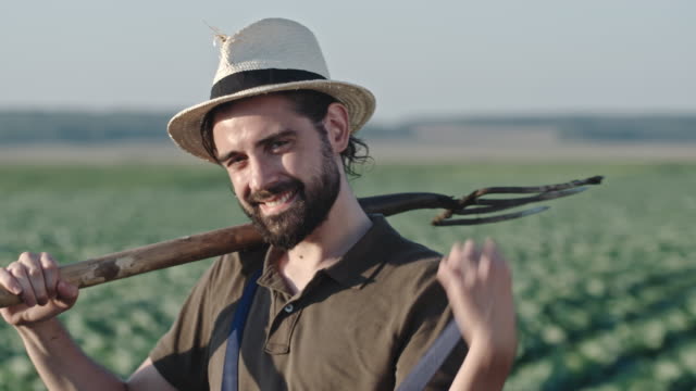 Retrato-de-sonriente-granjero-con-la-horca