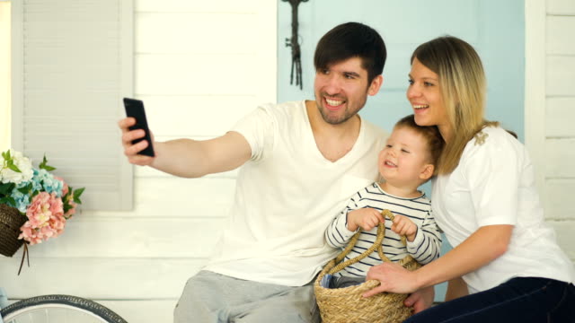 Vater-der-glücklichen-Familie-machen-Selfie-mit-seiner-Frau-und-kleinen-Sohn-vor-ihrer-Haustür
