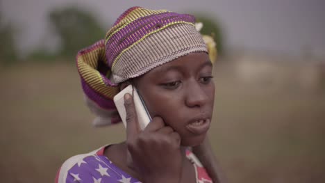 Porträt-einer-jungen-afrikanischen-Bäuerin,-die-spontan-auf-ihrem-Handy-spricht