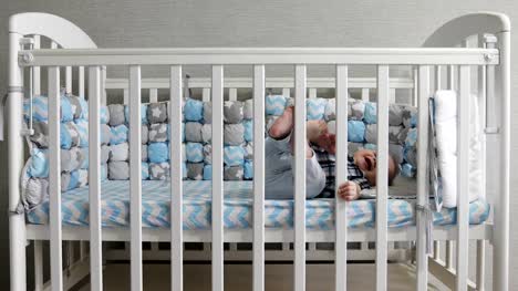 The-happy-kid-lies-in-a-baby-crib.