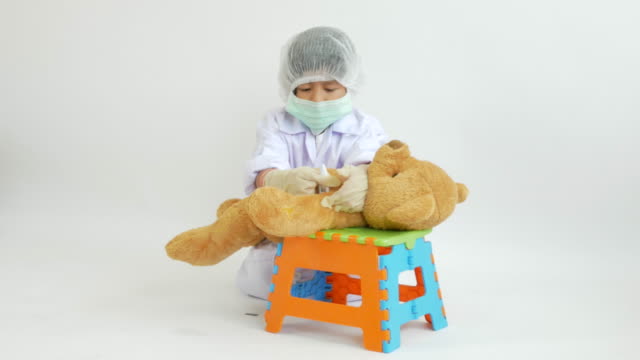Asian-child-playing-doctor-with-bear-doll
