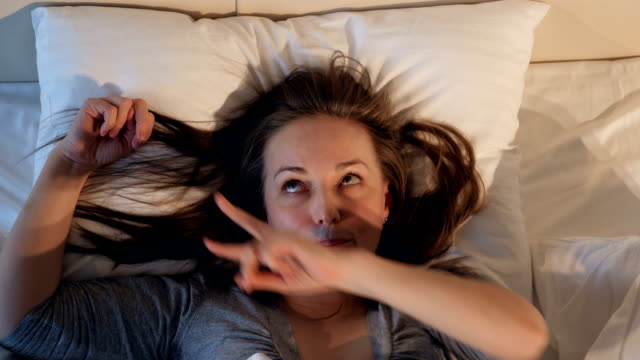 Cheerful-woman-dancing-in-the-bed.-Close-up.
