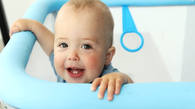 Baby-Boy-lächelnd-in-die-Kamera-während-der-ständigen-manege