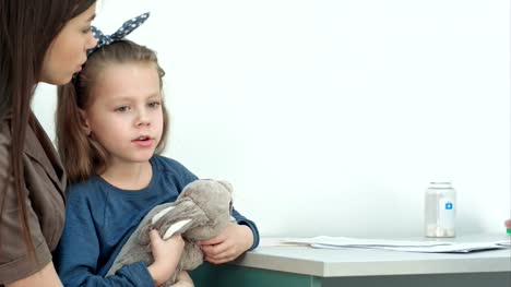 Male-pediatrician-checking-little-girl-head-for-fever