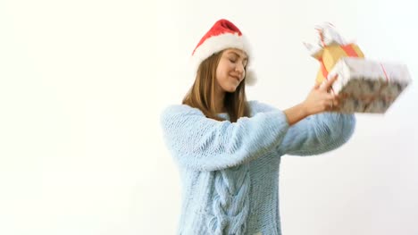 Süße-Blonde-in-Nikolausmütze-tanzen-mit-festlichen-Geschenken-auf-weißem-Hintergrund