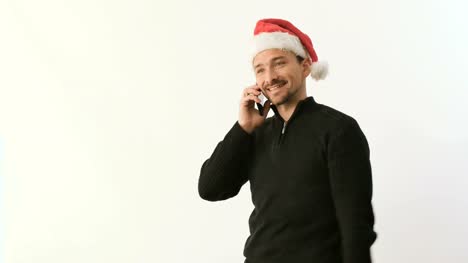 Der-Mann-in-der-Weihnachtsmütze-sprechen-über-Telefon-und-halten-ein-Geschenk-in-der-hand-auf-weißem-Hintergrund